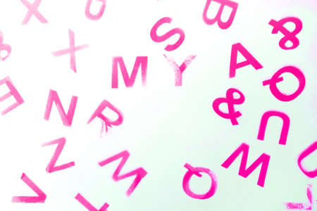 Silhouettes of alphabet letters on pink background. English letters stamp. Top view. Copy space for your creative designの写真素材