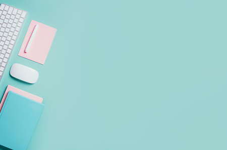 White mouse, keyboard, notebook, pen on blue background. Top view. Copy space. Flat lay. Remote job,...