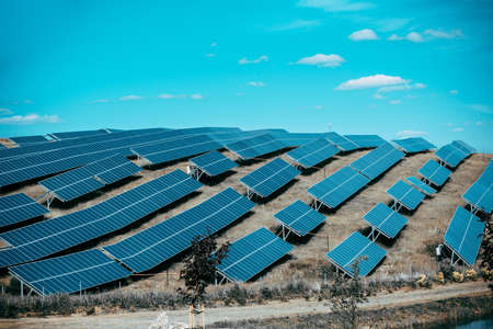 Solar panels against blue sunny sky produce green, environmentally friendly energy from sun. Blue solar panel background of photovoltaic modules for renewable energy. Copy spaceの写真素材