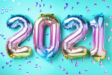 Colorful foil balloons made numbers 2021 on blue background with light bokehs. Happy new year celebration party. Greetings and congratulation conceptの写真素材