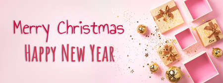 Gift box, shiny gold disco balls, sparkling gold glitter on pink background. New year baubles, star sparkles. New year, Christmas, Valentines day concept of greetings. Copy text. Top viewの写真素材