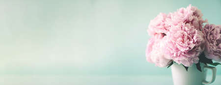 Wedding, birthday, anniversary bouquet. Pink peony flower on blue background. Copy space. Trendy pastel floral composition. Woman day, Mothers day. Macro of peonies flowersの写真素材