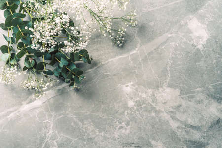 Flowers composition. Mock up. White gypsophila flowers and eucalyptus branches on marble background. Flat lay, top view, copy space. Wedding, birthday, anniversary bouquet. Woman day, Mothers dayの写真素材
