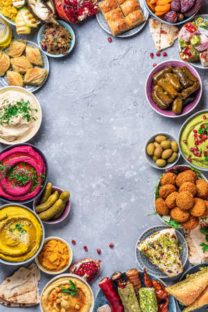 Mediterranean appetizer concept. Arabic traditional cuisine. Middle Eastern meze with pita, olives, hummus, stuffed dolma, falafel balls, pickles, babaganush, vegetables, pomegranate, eggplantsの写真素材