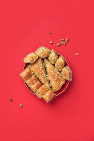 Turkish dessert baklava with pistachios on red background. Top view. Copy space. Set of assorted traditional eastern desserts. Arabian sweets, turkish delight.の写真素材