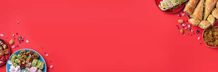 Middle Eastern sweets on red background. Arab dessert, baklava, halva, rahat lokum, sherbet, nuts, pistachios, dates, raisins, dried apricots, churchkhela, cookies. Top view. Flat lay. Copy spaceの写真素材