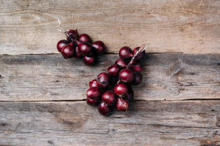 Bunch of purple onions on wooden background. Top view. Copy space. Autumn harvestの写真素材