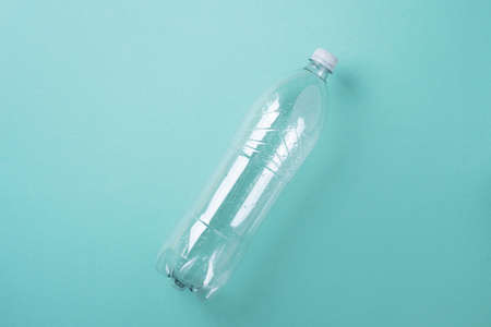 Empty rumpled used plastic bottle on blue background. Top view, copy space. Pollution, environmental protection concept. Reuse garbage, recycle, plastic free. Earth, world water dayの写真素材