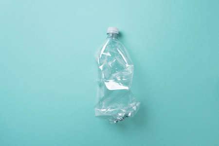 Empty rumpled used plastic bottle on blue background. Top view, copy space. Pollution, environmental protection concept. Reuse garbage, recycle, plastic free. Earth, world water dayの写真素材