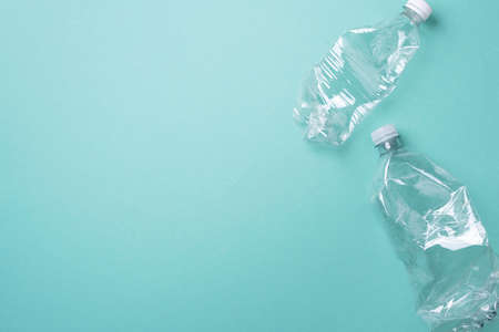 Empty rumpled used plastic bottle on blue background. Top view, copy space. Pollution, environmental protection concept. Reuse garbage, recycle, plastic free. Earth, world water dayの写真素材