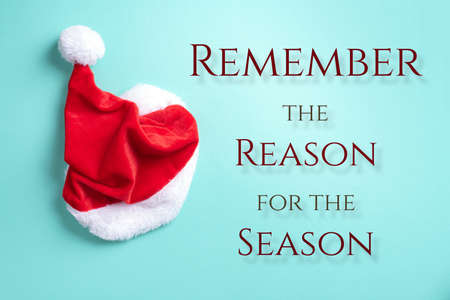 Red Santa Claus hat on blue background. Top view. Copy space. Advent time. Christmas greeting card. Remember the real Reason of the Season. Christian Christmas concept. Jesus Christ bornの写真素材