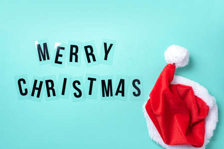 Bright red Santa Claus hat on blue background. Top View. Copy space. Merry Christmas concept. Banner. Advent time. New year composition. Decoration for winter holidays celebration. Greeting cardの写真素材