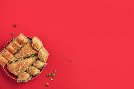 Turkish dessert baklava with pistachios on red background. Top view. Copy space. Set of assorted traditional eastern desserts. Arabian sweets, turkish delight.の写真素材
