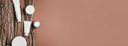 White unlabelled cosmetic bottle on dry wooden bark background. Skin care, organic body treatment, skin nutrition concept. Eco friendly product. Organic cosmetics. Moistening, dry skin conceptの写真素材