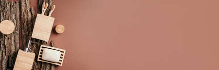 Zero waste, plastic free, sustainable concept. Bamboo bath accessories - soap dish, soap dispenser, tooth brush, organic dry shampoo for personal hygiene on wooden bark texture. Copy space. Top view.の写真素材