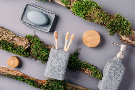 Zero waste, plastic free, sustainable concept. Bamboo bath accessories - soap dish, soap dispenser, tooth brush, organic dry shampoo for personal hygiene on green moss texture. Copy space. Top view.の写真素材