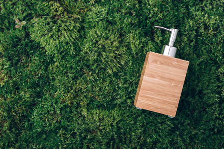 Bamboo soap dispenser on green moss background. Top view. Copy space. Skin care, body treatment, spa concept. Vegan eco friendly, organic cosmetics. Biophilic design, wild natureの写真素材