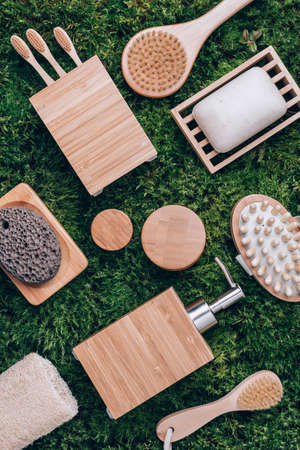 Zero waste, plastic free, sustainable concept. Bamboo bath accessories - soap dish, soap dispenser, tooth brush, organic dry shampoo for personal hygiene on green moss texture. Copy space. Top view.の写真素材