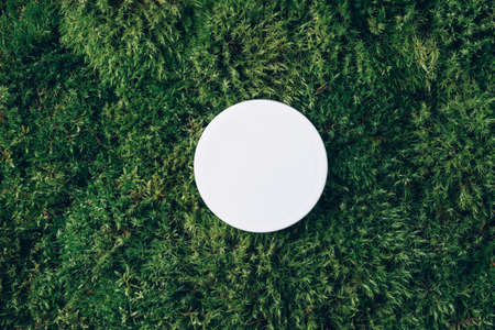 Body butter jar on green moss background with copy space. Skin care product, natural cosmetic, cream concept. Top view, flat layの写真素材