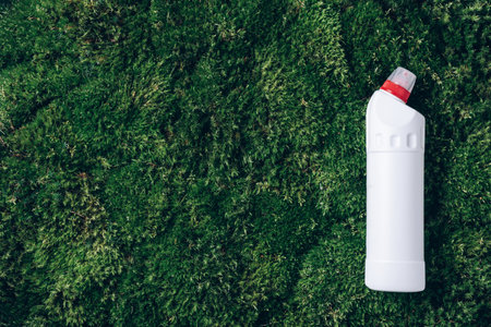 White plastic bottle of cleaning product, household chemicals or liquid laundry detergent on green grass, moss background. Top view. Flat lay. Copy space. Detergent bottleの写真素材