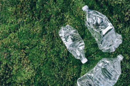 Plastic bottles on green moss background. Recycle plastic, waste pollution concept. Top view, copy space. Environmental protection concept. Reuse garbage, plastic free. Earth, world water dayの写真素材