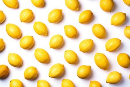 Immune system booster, alkaline diet. Fresh lemons pattern isolated on white background. Top view. Flat lay. Citrus fruits. Vitamins for health. Liposomal vitamin C. Lemon for vegan, vegetarian dietの写真素材