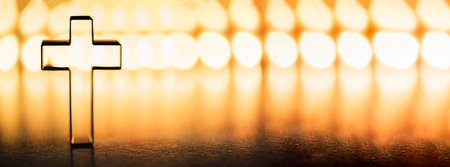Christian cross on yellow background with soft bokeh lights background. Copy space. Banner. Church worship, salvation concept. Faith symbol in Jesus Christ. Holy cross for good friday, Easter dayの写真素材