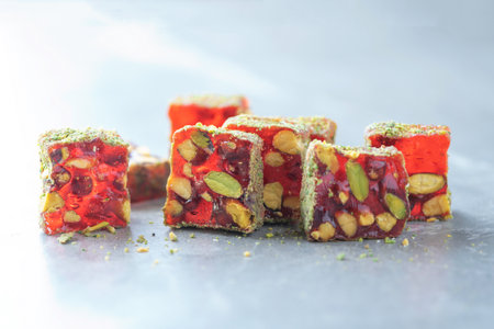 Turkish delight - lokum or rahat lokum with pistachios on grey background. Traditional eastern cuisine. Traditional middle eastern sweets. Jewish, turkish, arabic national dessert. Turkish delightの写真素材