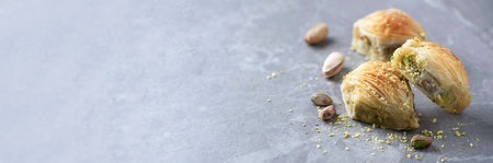 Baklava with pistachios on grey background. Jewish, turkish, arabic traditional national dessert. Macro. Selective focus. Copy space. Eastern sweets, turkish delightの写真素材