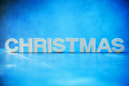 Word Christmas made of white concrete letters on neon light background. Copy space for your creative design. Festive invitation, greeting cardの写真素材