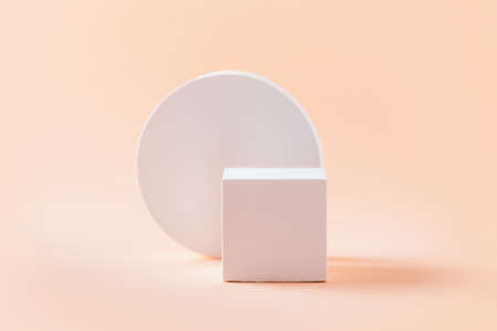 Abstract empty geometric shape podium for product on pastel beige background. Copy space. White cube...