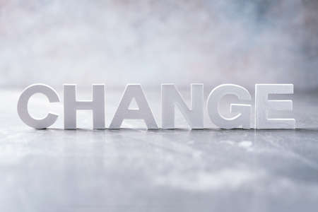 Word change word made with cement letters on grey marble background. Copy space. Concept
