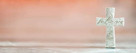 Stone cross with inscription Believe on grey background, Copy space. Christian backdrop. Biblical faith, gospel, salvation concept. Bannerの写真素材