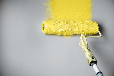 Demonstrating trendy Color of the Year 2021. Illuminating Yellow and Ultimate Gray. Brush and open paint can with on color background. Appartment renovation, repair, building and home design conceptの写真素材