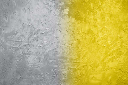 Demonstrating trendy Color of the Year 2021. Illuminating Yellow and Ultimate Gray. Duotone concrete cement wall texture. Background with copy space for design. Color Psychology. Depression treatmentの写真素材