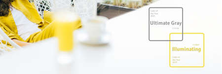 Trendy Illuminating and Ultimate gray duotone picture. Style girl with yellow clothes, glass of juice. Minimalistic style outdoor interior. Demonstrating trendy Color of the Year 2021. Bannerの写真素材