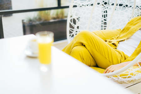 Trendy Illuminating and Ultimate gray duotone picture. Style girl with yellow clothes, glass of...