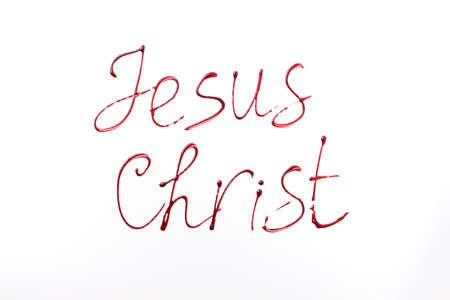 Name Jesus Christ written with blood isolated on white background. Top view. Palm Sunday, Good Friday, Easter concept, Christ resurrection. Christianity symbol and faith.の写真素材