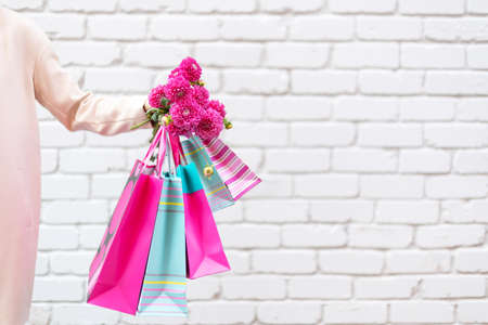 Stylish girl in white clothes holding pink shopping bags. Sale, discount, black friday concept. Shopping mall and outletの写真素材