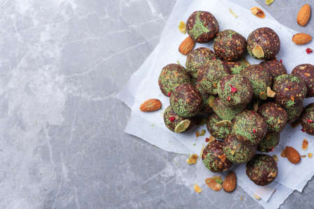 Raw energy balls with matcha tea powder on grey background. Raw vegan, vegetarian sweets. Sugar free, gluten free, lactose freeの写真素材