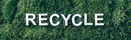 Word RECYCLE on moss, green grass background. Top view. Copy space. Banner. Biophilia concept. Nature backdrop. Earth day conceptの写真素材