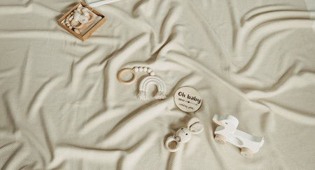 Set of newborn stuff and baby accessories. Cute shoes, wood toys on beige background. Baby shower, infant care concept. Gender neutral parenting. Top view, flat lay, copy spaceの写真素材
