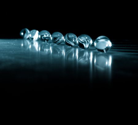 Row of Cat Eye Marbles in Single Point Blue Filter Lighting
