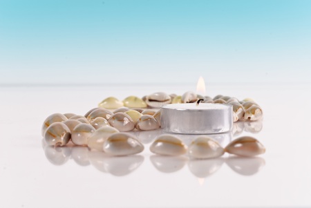 Tranquil Setting with Shells Lit Candle and Shells with Blue Gradientの写真素材