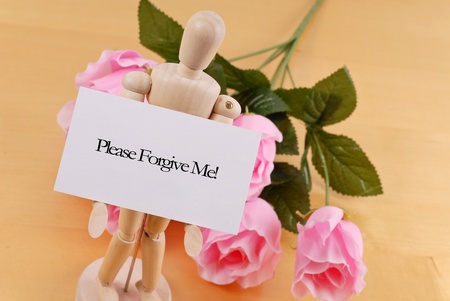 Wood Doll Holding Up an Apology Noteの写真素材