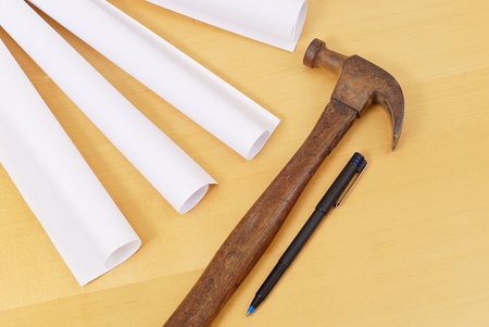 Old Hammer with Pen and Blue Prints Rolled Upの写真素材