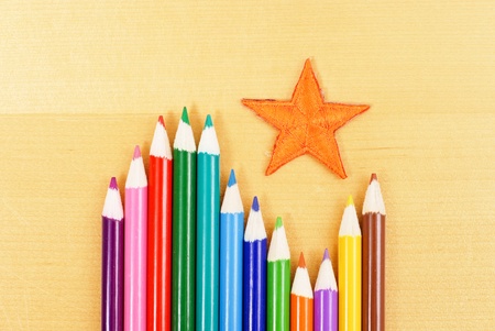Orange Star with Colored Pencils on Tableの写真素材