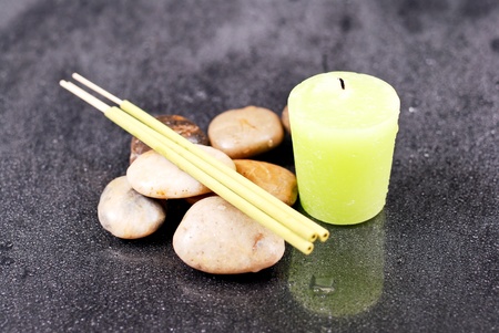 Lime Scented Candle and Incense with Rocks on Wet Glassの写真素材