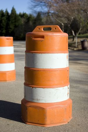 An orange traffic barrel on a small road.の写真素材