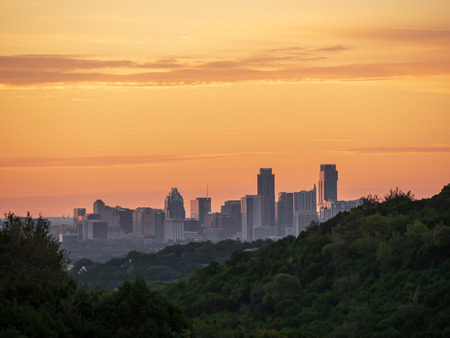 Skyline shot of Austin Texas downtown nestled between hills during vibrant golden sunriseの写真素材